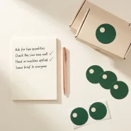 Checklist for comparing label printing price quotes, with round label samples and a kraft carton